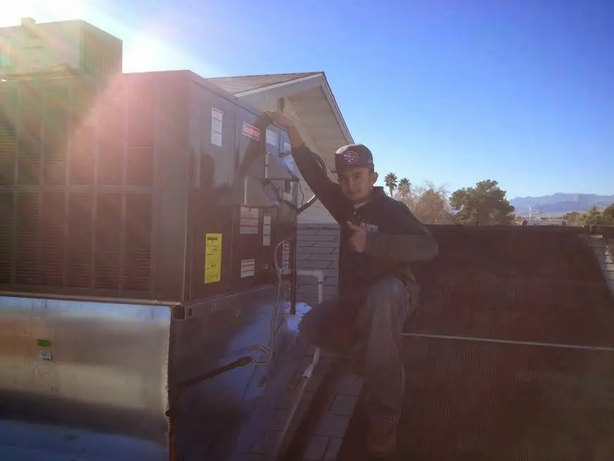 HVAC technician performing Boiler Repair on a rooftop unit in Joppatowne